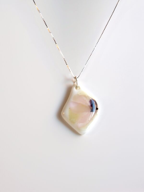 Pendentif en verre blanc légèrement ondulé, orné d’un motif floral pastel semblant peint à l’aquarelle